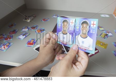 Bauru, Brazil - 12.09.22: Closeup Of Hand Holding Collectible Football Player Sticker To Stick At Pa