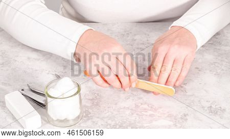 Woman Finishing Her Manicure At Home With Simple Manicure Tools. Filing Nails With A Nail Filer.