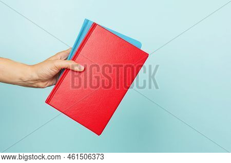 Woman Hands Holding Books With Blank Cover Over Light Blue Background. Education, Back To School, Se