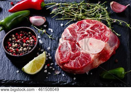 Uncooked Osso Buco, Veal Shank Steak With Marrowbone On Black Stone Board With Peppercorns, Fresh Th