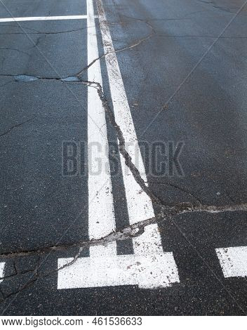 Road With Road Marking Lines. Double Solid White Center Lines. Cracked Asphalt Surface.