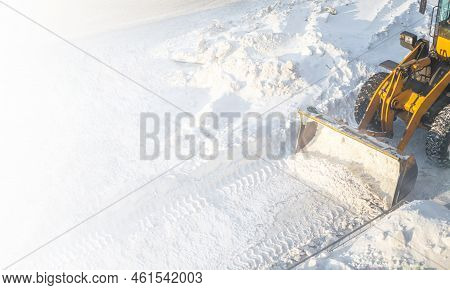 A Large Orange Tractor Removes Snow From The Road And Clears The Sidewalk. Cleaning And Clearing Roa