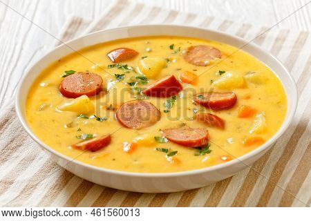 Kartoffelsuppe, German Creamy Potato Soup With Sausages In White Bowl On White Wooden Table