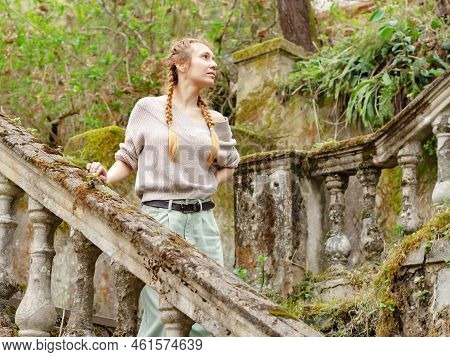 Woman On An Abandoned Staircase Outdoors. Woman Walking On The Steps Of An Abandoned Park. Woman Wal
