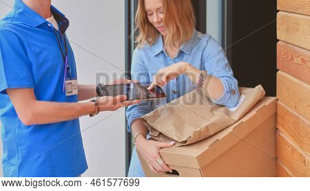 Smiling Delivery Man In Blue Uniform Delivering Parcel Box To Recipient - Courier Service Concept. S
