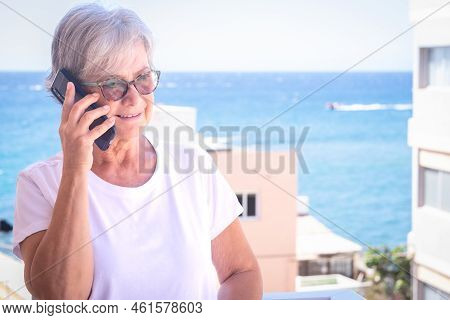 Lovery Mature Senior Lady Having Conversation With Friends Standing Outdoor With Blue Sea On Backgro