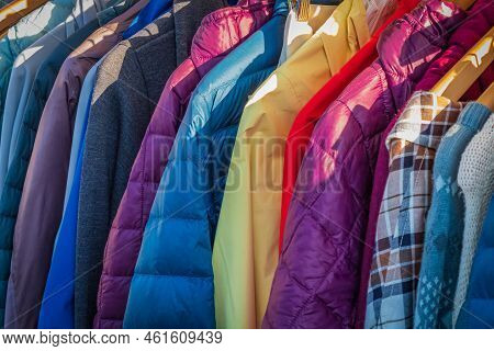 Row Of Autumn Coats Hanging On Rack, Shopping. Cloth Shop, Clothing Store, Female And Male Collectio
