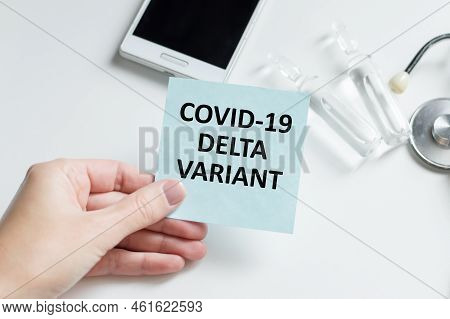 Doctor's Hand In Blue Glove With White Paper And Text Covid-19 Delta Variant. Concept Of Medical Var