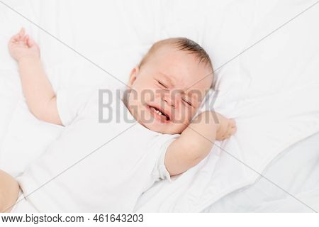 The Baby Is Crying In His Crib . The Baby 's Teeth Are Teething . Colic In Babies . Hungry Baby . Ba