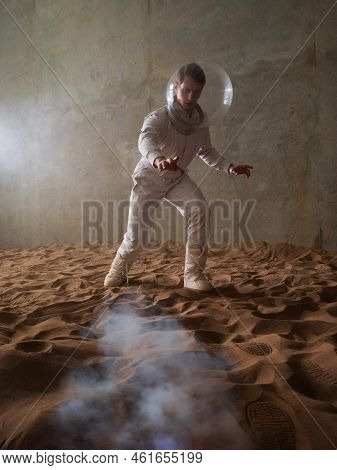 Fear Of The Unknown On Alien Planets. An Astronaut In A White Spacesuit Walks Through An Abandoned C
