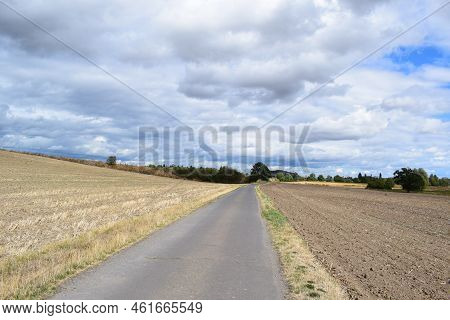 Straight Road Through Harvested Fields In The Eifel