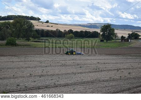 Thür, Germany - 09 08 2022: Tractor In The Field Followed By Birds