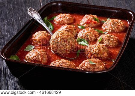 Italian Porcupine Balls, Ground Beef And Rice Meatballs In Tomato Sauce In Rustic Baking Dish On Dar