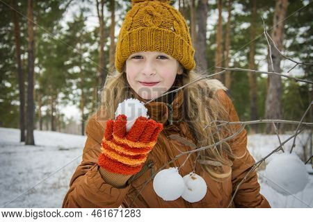 In Winter, On A Frosty Day In The Forest, A Girl Makes Snowballs With A Snowball And Decorates Tree 