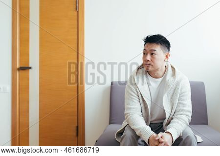 Young Asian Man Waiting For An Interview Or Meeting Sitting In The Hallway In The Waiting Room. Stud