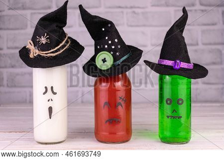 Drink Idea For Halloween Party. Drinks In Bottles With Monster Faces. Jack-o-lantern Face On Glass.