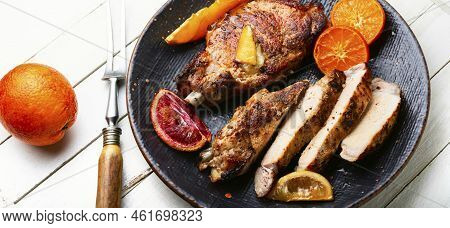 Pork Steak On The Bone Baked With Citrus Fruits.