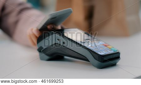 Woman At Check-in Desk At Counter Pays With Smartphone Through Nfc Contactless Payment From Mobile P