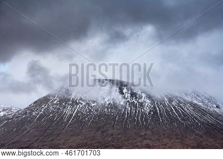Beautiful Winter Landscape Image Of Beinn A' Chaladair In Scotland With Dramatic Skies Overhead