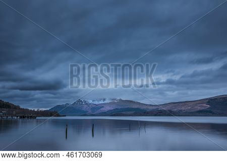 Stunning Landscape Image Of Loch Lomond And Snowcapped Mountain Range In Distance Viewed From Small 
