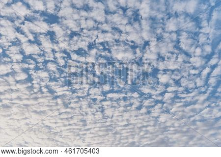 Texture Of Altocumulus Fluffy Clouds Illuminated By Sunlight On Blue Sky As Abstract Background