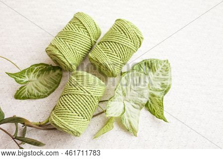 Handmade Macrame Braiding And Cotton Threads On White Textile Background. Green Cotton Macrame Cords