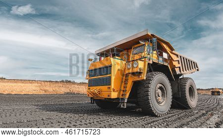 Large Quarry Dump Truck. Big Yellow Mining Truck At Work Site. Loading Coal Into Body Truck. Product