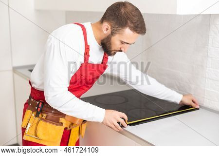 Craftsman Installs Hob In Kitchen. Household Appliance Installation Services Concept