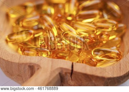 Yellow Omega 3 Capsules In A Cracked Wooden Bowl. Health Supplement. Rustic Style View