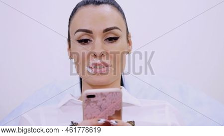 Close-up, The Patient Sits In The Cosmetology Clinic With A Superimposed Anesthetic Cream Pad On The