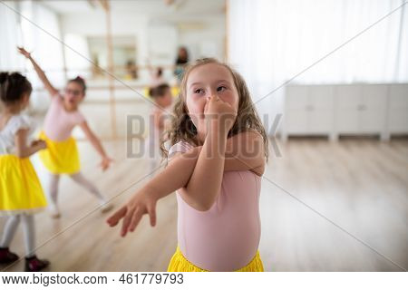 Little Girl With Down Syndrome Imitating Elephant, Having Fun During Ballet Leson At Dancing School.