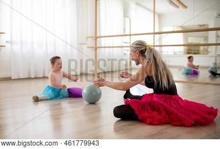 Little Girl With Down Syndrome Playing With Ball With Her Dance Lecteur In Ballet Studio.