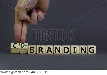 Branding Or Co-branding Symbol. Businessman Turns Wooden Cubes And Changes The Word Branding To Co-b