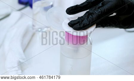 Close-up, The Hands Of The Beautician In Black Rubber Gloves Hold The Cotton Pad And Moisten It In A