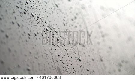 Close-up, On The Car Glass Windows Rain Drops Drip Down A Multitude Of Streams. Its Raining Heavily,