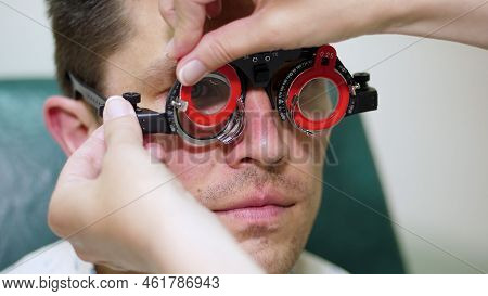 Close-up, Portrait Of Handsome Young Man Trying On Blue Sunglasses At Optical Store, Optician Retail