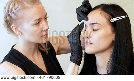 Beauty Saloon. The Master Wipes The Eyebrow Area With A Cotton Disc Moistened With Antiseptic