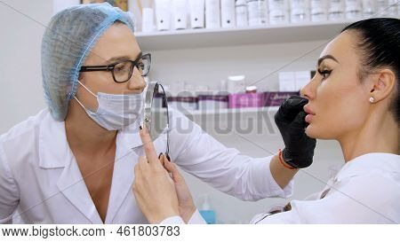 Medical Office, A Female Doctor In Glasses, White Uniform, Medical Cap And A Bandage, Probes The Pat