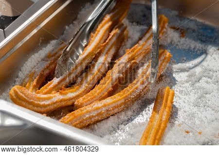 Chef Preparing Homemade Crunchy Churros With Powdered Sugar At Summer Outdoor Food Market - Close Up