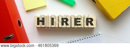 Wooden Cubes With Word Hirer On The Office Desk. Folder And Other Office Supplies. Work Space.