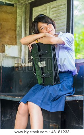Милой тайский Shoolgirl Daydreaming в старой автобусной остановки