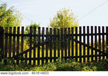 An Old Wooden Fense In The Countryside. Shabby Wooden Planks Fense. Rural Scene. Nature Concept. Sky