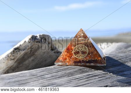 An Image Of An Orgonite Pyramid Energy Generator With The Tree Of Life Symbol Resting On A Weathered