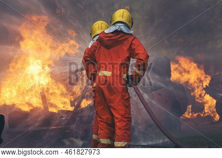 Firefighter Rescue Training In Fire Fighting Extinguisher. Firefighter Fighting With Flame Using Fir