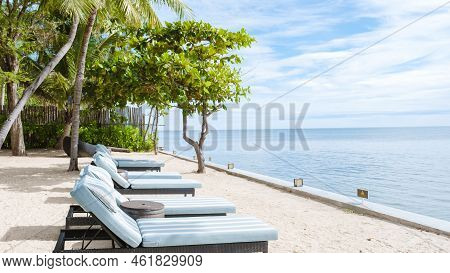 Tropical Pool With Palm Trees And Beach Bed Chairs, Beach Chairs With Beach Towel At A Pool