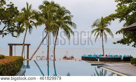 Tropical Pool With Palm Trees And Beach Bed Chairs, Beach Chairs With Beach Towel At A Pool