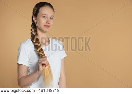 Teenage Girl With Strong Healthy Braided Hair On Beige Background, Space For Text