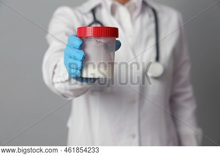 Doctor Holding Container With Sperm On Grey Background, Closeup