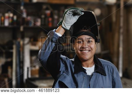 Closeup Portrait Of Smiling Female Welder Looking At Camera In Industrial Factory, Copy Space