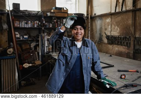 Waist Up Portrait Of Multiethnic Female Welder Smiling At Camera In Industrial Factory Workshop, Cop
